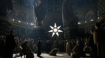 Movie still from “Game of Thrones” (2011), created by D.B. Weiss – A group of people standing in a room with a star in the center; Extreme Wide shot, High angle