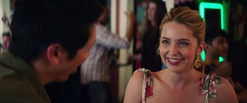 Movie still from “All My Life” (2020), directed by Marc Meyers – A woman smiling at the camera while a man is standing in the background; Close Up shot, Over the shoulder angle