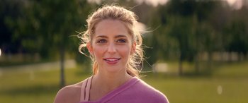 Movie still from “All My Life” (2020), directed by Marc Meyers – A beautiful woman wearing a pink shirt and smiling for the camera; Close Up shot, Over the shoulder angle
