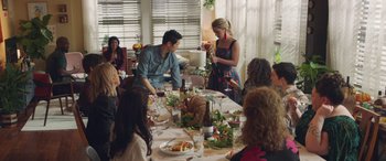 Movie still from “All My Life” (2020), directed by Marc Meyers – A group of people sitting around a table with plates of food on top of it; Medium shot, Over the shoulder angle