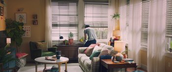 Movie still from “All My Life” (2020), directed by Marc Meyers – A man in a living room cleaning the window; Wide shot, Low angle