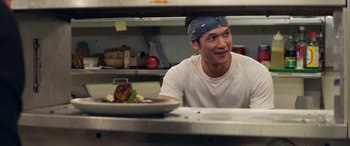 Movie still from “All My Life” (2020), directed by Marc Meyers – A man sitting at a table in front of a plate of food; Medium shot, Over the shoulder angle