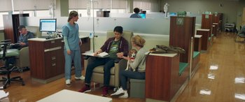 Movie still from “All My Life” (2020), directed by Marc Meyers – A man and a woman sitting in a hospital room with a dog; Wide shot, High angle