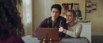 Movie still from “All My Life” (2020), directed by Marc Meyers – A man and a woman sitting at a table looking at a laptop computer; Medium shot, Over the shoulder angle