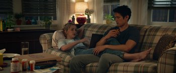 Movie still from “All My Life” (2020), directed by Marc Meyers – A man and a woman sitting on a couch in a living room; Wide shot, High angle