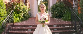 Movie still from “All My Life” (2020), directed by Marc Meyers – A woman in a white dress holding a bouquet of flowers; Medium shot, Over the shoulder angle