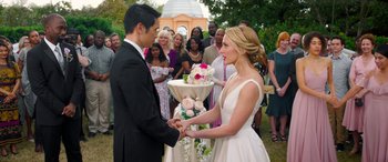 Movie still from “All My Life” (2020), directed by Marc Meyers – A man and a woman holding hands in front of a group of people; Medium shot, Over the shoulder angle