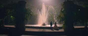 Movie still from “All My Life” (2020), directed by Marc Meyers – A man and a woman standing in front of a fountain; Extreme Wide shot, Low angle