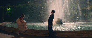 Movie still from “All My Life” (2020), directed by Marc Meyers – A man standing in front of a water fountain; Wide shot, Low angle