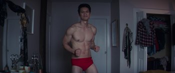 Movie still from “All My Life” (2020), directed by Marc Meyers – A man in a red swim trunks is posing for a picture; Medium shot, Low angle