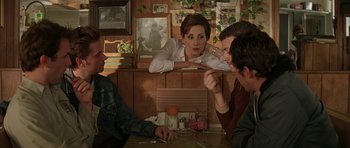 Movie still from “All the Real Girls” (2003), directed by David Gordon Green – Three people sitting at a table in front of a woman; Medium shot, Over the shoulder angle