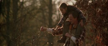 Movie still from “All the Real Girls” (2003), directed by David Gordon Green – A man and a woman in the woods picking berries; Medium shot, Low angle