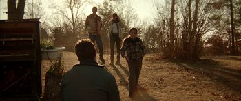 Movie still from “All the Real Girls” (2003), directed by David Gordon Green – A group of people walking on a dirt path; Wide shot, Over the shoulder angle