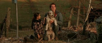 Movie still from “All the Real Girls” (2003), directed by David Gordon Green – A man and a girl with a dog in a fenced in area; Medium shot, Low angle