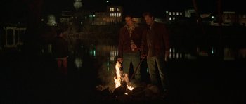 Movie still from “All the Real Girls” (2003), directed by David Gordon Green – A couple of men standing next to a fire; Wide shot, High angle