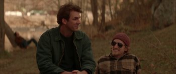 Movie still from “All the Real Girls” (2003), directed by David Gordon Green – Two men sitting in the grass talking to each other; Medium shot, Over the shoulder angle