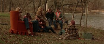 Movie still from “All the Real Girls” (2003), directed by David Gordon Green – A group of people sitting in the grass; Wide shot, High angle