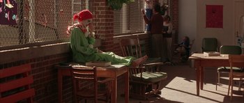 Movie still from “All the Real Girls” (2003), directed by David Gordon Green – A clown that is sitting on a table; Wide shot, High angle