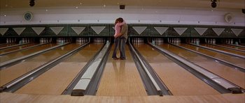 Movie still from “All the Real Girls” (2003), directed by David Gordon Green – Two people are kissing in a bowling alley; Wide shot, Low angle