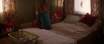 Movie still from “All the Real Girls” (2003), directed by David Gordon Green – A woman sitting on a bed looking at a mirror; Wide shot, High angle