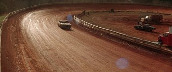 Movie still from “All the Real Girls” (2003), directed by David Gordon Green – A car driving down a dirt road on a dirt track; Extreme Wide shot, High angle