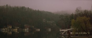 Movie still from “All the Real Girls” (2003), directed by David Gordon Green – A body of water surrounded by a forest; Extreme Wide shot, High angle