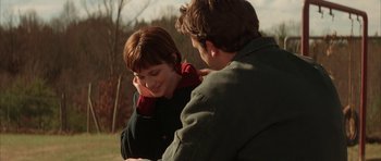 Movie still from “All the Real Girls” (2003), directed by David Gordon Green – A man and a woman sitting in a field; Medium shot, Over the shoulder angle