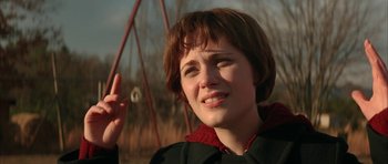 Movie still from “All the Real Girls” (2003), directed by David Gordon Green – A young woman holding up a peace sign with one hand; Close Up shot, Over the shoulder angle