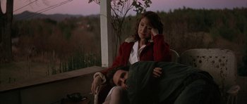 Movie still from “All the Real Girls” (2003), directed by David Gordon Green – A woman sitting on a chair next to a sleeping man; Medium shot, High angle
