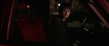 Movie still from “All the Real Girls” (2003), directed by David Gordon Green – A person sitting in a chair in a dark room; Medium shot, Over the shoulder angle