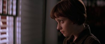 Movie still from “All the Real Girls” (2003), directed by David Gordon Green – A woman with short brown hair is looking to the side; Close Up shot, Over the shoulder angle