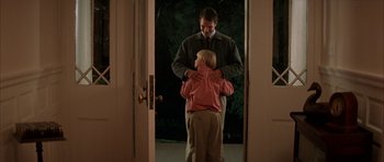 Movie still from “All the Real Girls” (2003), directed by David Gordon Green – A man and a little girl standing in front of a door; Medium shot, Over the shoulder angle