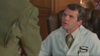 Movie still from “Alligator” (1980), directed by Lewis Teague – A man wearing a lab coat talking to another man in a suit; Close Up shot, Low angle