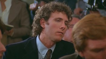 Movie still from “Alligator” (1980), directed by Lewis Teague – A person wearing a suit and tie; Close Up shot, Over the shoulder angle