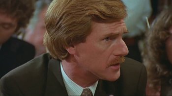 Movie still from “Alligator” (1980), directed by Lewis Teague – A person wearing a suit and tie; Close Up shot, Low angle