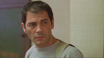 Movie still from “Alligator” (1980), directed by Lewis Teague – A person wearing a gray shirt; Close Up shot, Low angle