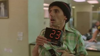 Movie still from “Alligator” (1980), directed by Lewis Teague – A man holding up a digital clock with the number 2 3 on top of it; Close Up shot, Low angle