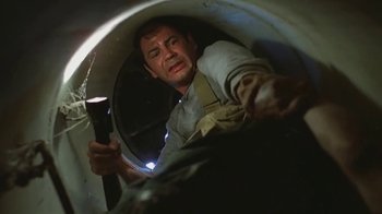 Movie still from “Alligator” (1980), directed by Lewis Teague – A man holding a cell phone in his hand; Medium shot, Low angle