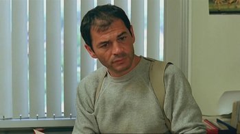 Movie still from “Alligator” (1980), directed by Lewis Teague – A person sitting down with a bag on his shoulder; Close Up shot, Low angle