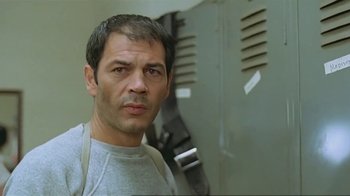 Movie still from “Alligator” (1980), directed by Lewis Teague – A person wearing a gray shirt; Close Up shot, Low angle