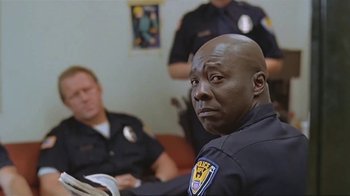 Movie still from “Alligator” (1980), directed by Lewis Teague – A police officer sitting in front of another officer in a room; Close Up shot, Over the shoulder angle