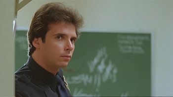 Movie still from “Alligator” (1980), directed by Lewis Teague – A man standing in front of a chalkboard in a classroom; Close Up shot, Low angle