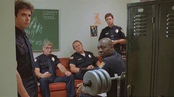 Movie still from “Alligator” (1980), directed by Lewis Teague – A group of police officers sitting in a room; Medium shot, Low angle