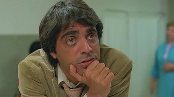 Movie still from “Alligator” (1980), directed by Lewis Teague – A person with his hand under his chin; Close Up shot, Low angle