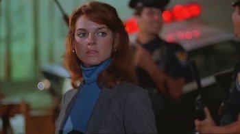 Movie still from “Alligator” (1980), directed by Lewis Teague – A person wearing a suit and tie; Close Up shot, Low angle