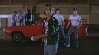 Movie still from “Alligator” (1980), directed by Lewis Teague – A group of young men standing next to each other in a parking lot; Medium shot, Low angle