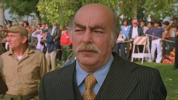 Movie still from “Alligator” (1980), directed by Lewis Teague – An older man in a suit and a tie; Close Up shot, Low angle