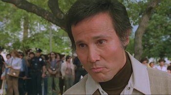 Movie still from “Alligator” (1980), directed by Lewis Teague – A person with a crowd in the background; Close Up shot, Low angle