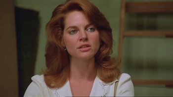 Movie still from “Alligator” (1980), directed by Lewis Teague – A person with long red hair; Close Up shot, Low angle