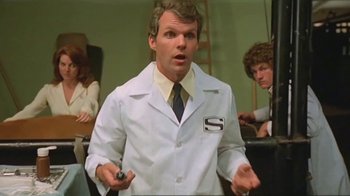 Movie still from “Alligator” (1980), directed by Lewis Teague – A man in a lab coat holding a pen in his hand; Medium shot, Low angle